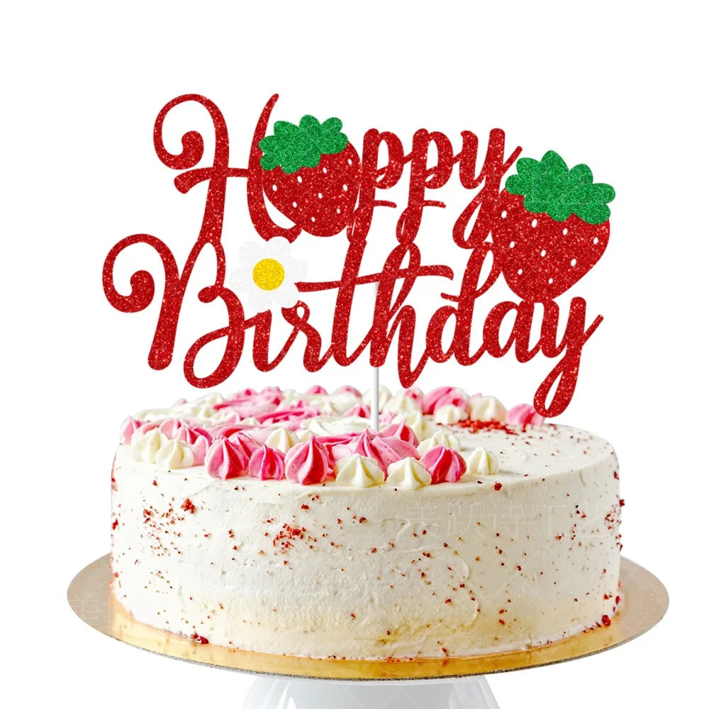 A cake decorated with red strawberry toppers spelling 'Happy Birthday' on a white frosting cake.