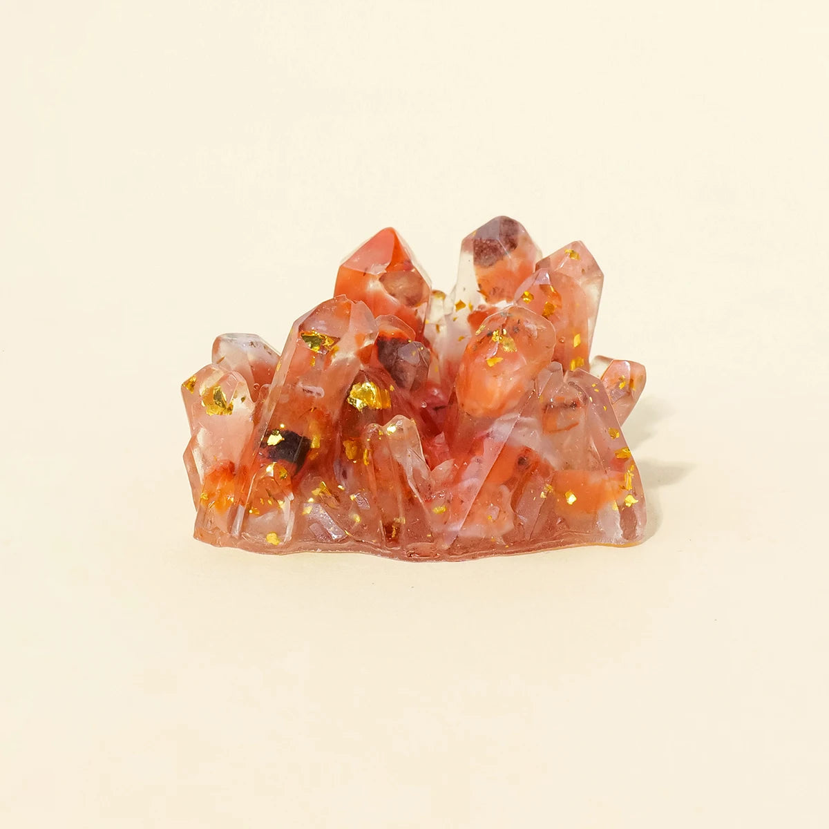 A cluster of reddish-pink and orange crystal stones used as a Reiki amulet or decorative figurine.