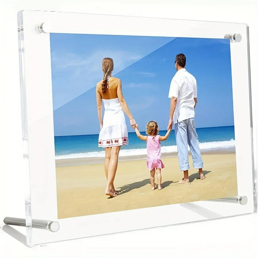A clear acrylic photo frame displaying a family of three walking on a beach with blue water and sky.