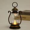 A vintage brass battery-powered desk lamp with an amber glow inside a clear glass bulb.