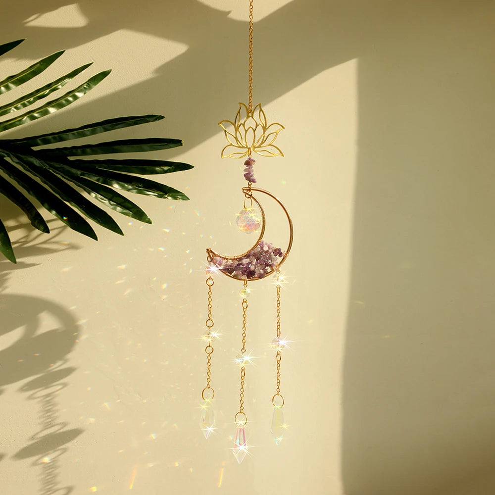A golden dreamcatcher hangs against a light background, featuring a sun motif and a purple crystal moon charm.