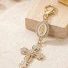 Gold pearl rhinestone cross keychain charm with a central oval and detailed design