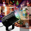 A black outdoor LED projector light is mounted, projecting festive Halloween and Christmas patterns onto a brick wall.