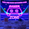 A vibrant neon sign featuring the word GAMER and a stylized controller icon on a dark blue background.