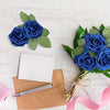 A bouquet of three artificial blue roses with green leaves and stems resting on brown paper.
