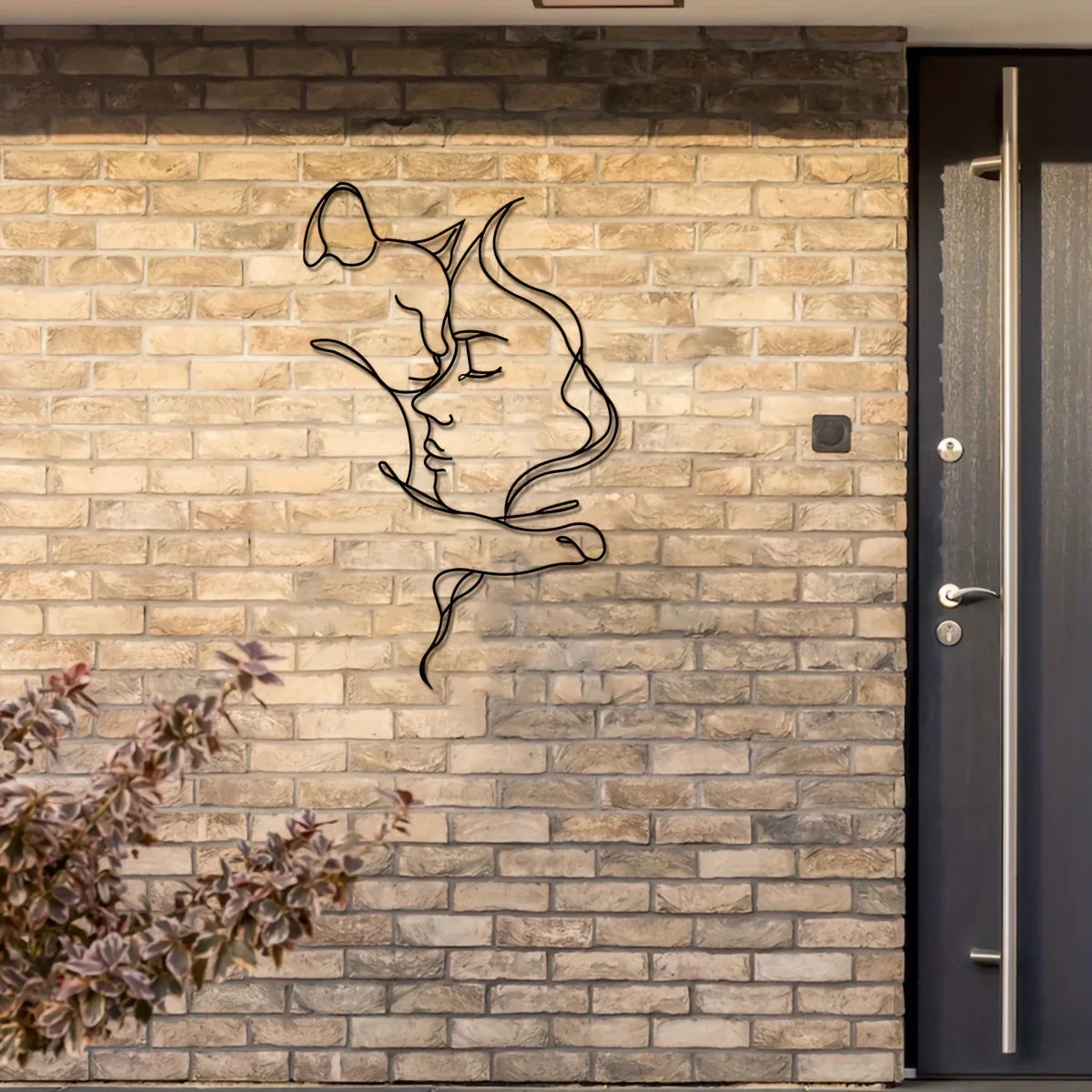 A modern silhouette of a cat and woman's profile carved into a textured brick wall.