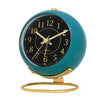 A teal minimalist Nordic alarm clock with a black face and gold accents.