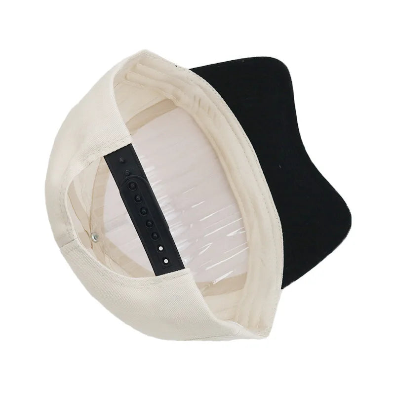 Casquette de baseball style camion beige brodée avec une visière noire.