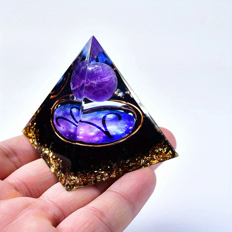 A dark purple and black pyramid crystal with an amethyst sphere is held in a hand.