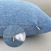 A close-up of a blue linen pillowcase with a visible zipper detail.