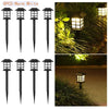 Eight black solar pathway lights with warm white illumination placed in a grassy outdoor setting.
