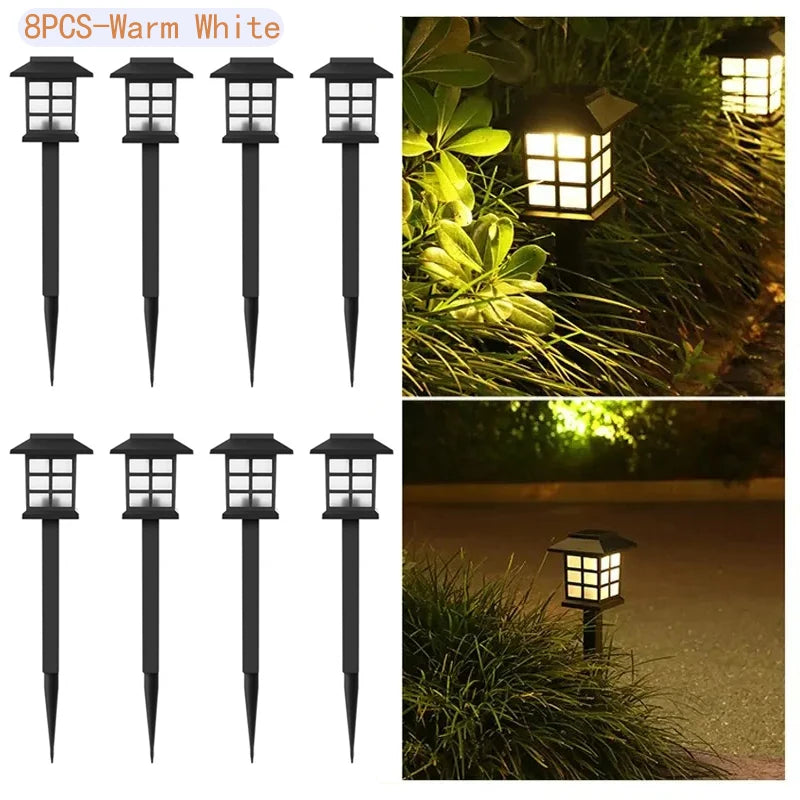 Eight black solar pathway lights with warm white illumination placed in a grassy outdoor setting.