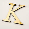 A gold acrylic mirror letter K wall sticker for decorative purposes.