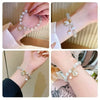 Close-up shots of a natural stone lily of the valley bracelet worn on wrists.