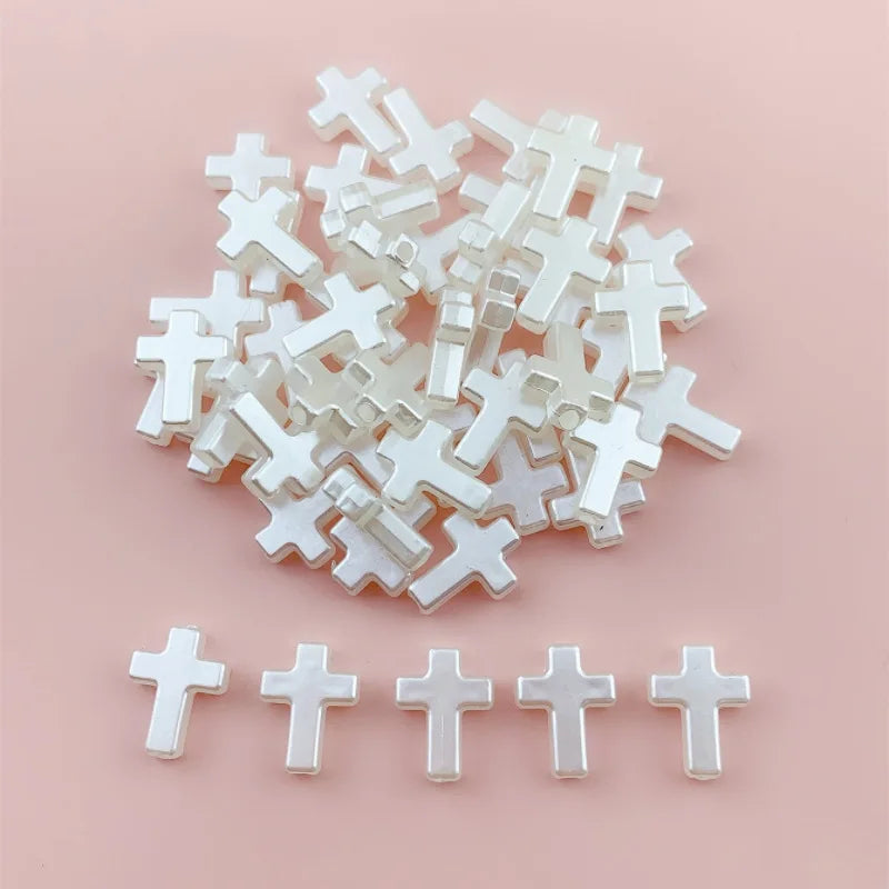 A pile of small, clear acrylic cross shape beads for DIY jewelry making