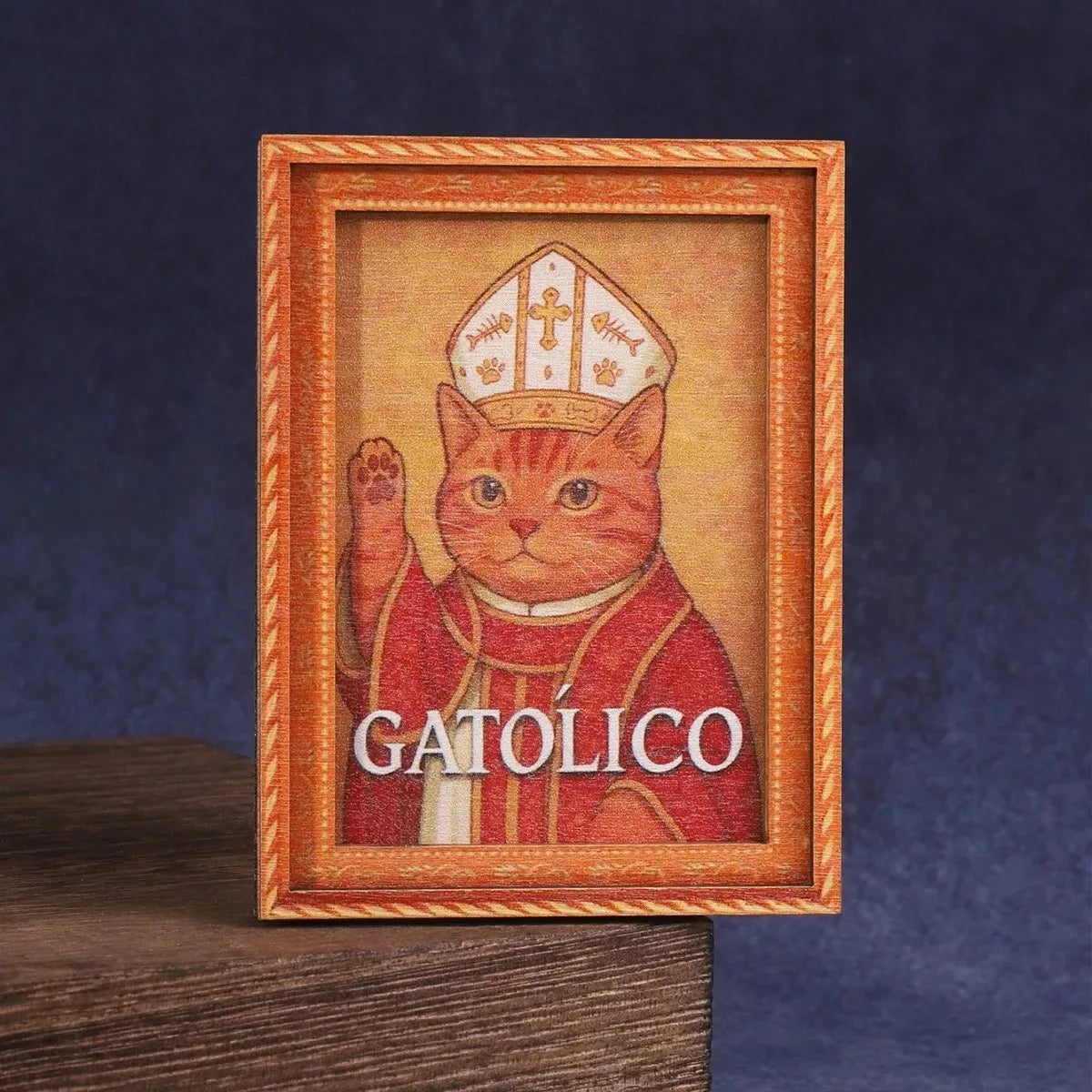 Impresión estilo pintura al óleo de un gato atigrado naranja con una túnica roja, enmarcado en madera.