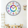 A colorful silent wall clock with numbers and hands hanging on a white wall.