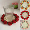 A display of hand-crocheted rose coasters featuring red and pink roses with cream centers.