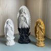 White resin statue of Our Lady of Guadalupe with a golden halo and dark base.