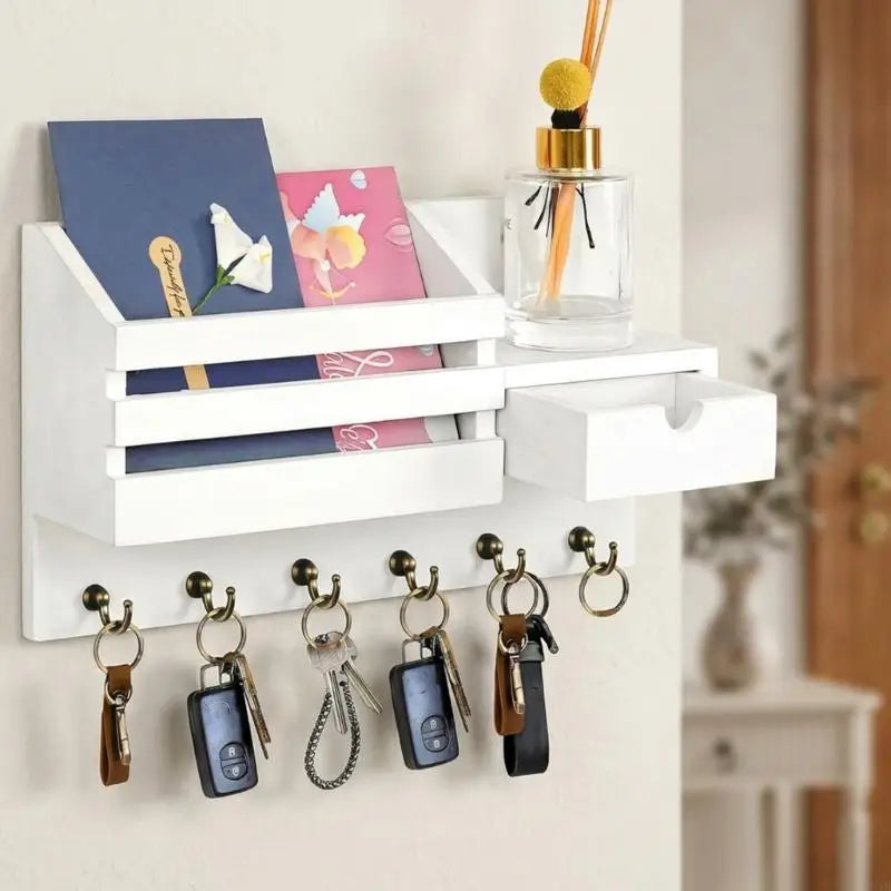 A white wall-mounted organizer featuring a mail slot and a drawer, with several keys hanging below.