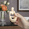 A hand holds a beige silicone mold shaped like a female figure for resin art and crafting.