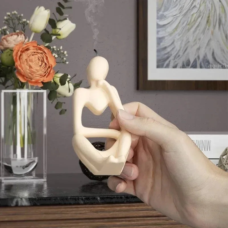 A hand holds a beige silicone mold shaped like a female figure for resin art and crafting.