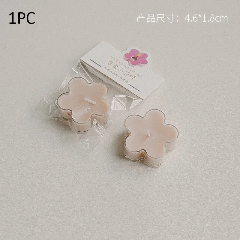 A single handmade soy wax flower tea light candle in a light pink color is shown packaged with a label and a small pink flowe