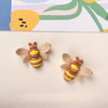 Two resin fridge magnets shaped like bees with yellow and brown stripes against a light background.