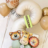 A set of light beige and yellow number balloons shaped like a jungle animal, including a tiger, giraffe, and lion face.