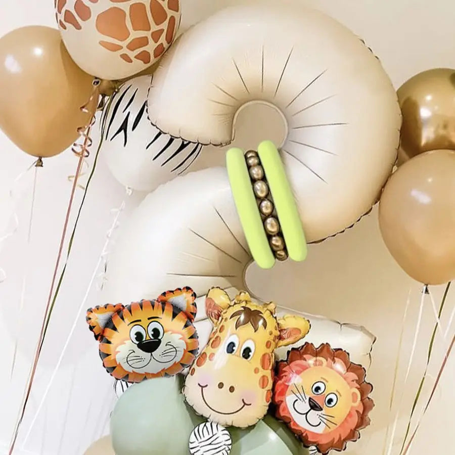 A set of light beige and yellow number balloons shaped like a jungle animal, including a tiger, giraffe, and lion face.