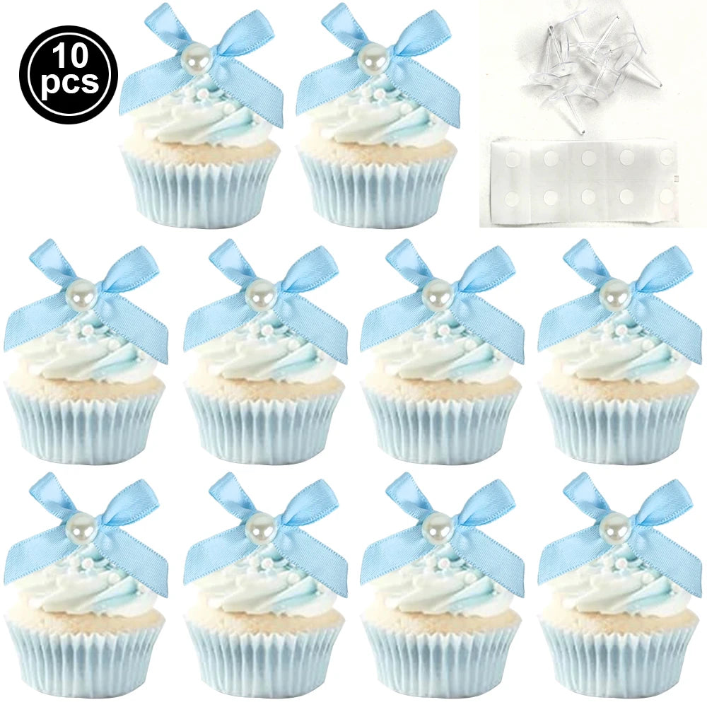 A set of ten light blue and white frosted cupcakes with pink bows for birthday or bridal shower decorations.