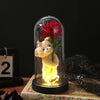 An eternal rose LED decorative flower in a glass dome sits on a wooden surface.