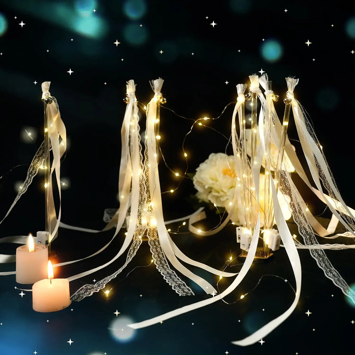 Elegant LED glow wands with ribbons and bells suspended against a dark background.