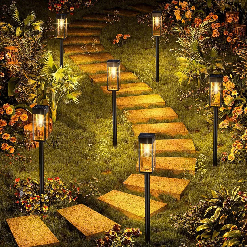 A pathway lined with retro solar lights leading through a lush, overgrown garden.