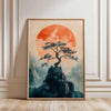 A framed canvas print featuring a silhouette of a tree against a large orange sun, set in a misty landscape.