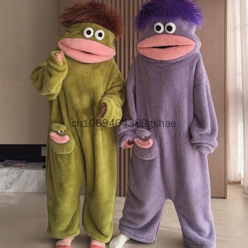 A pair of fuzzy green and purple monster onesie pajamas for couples standing together.