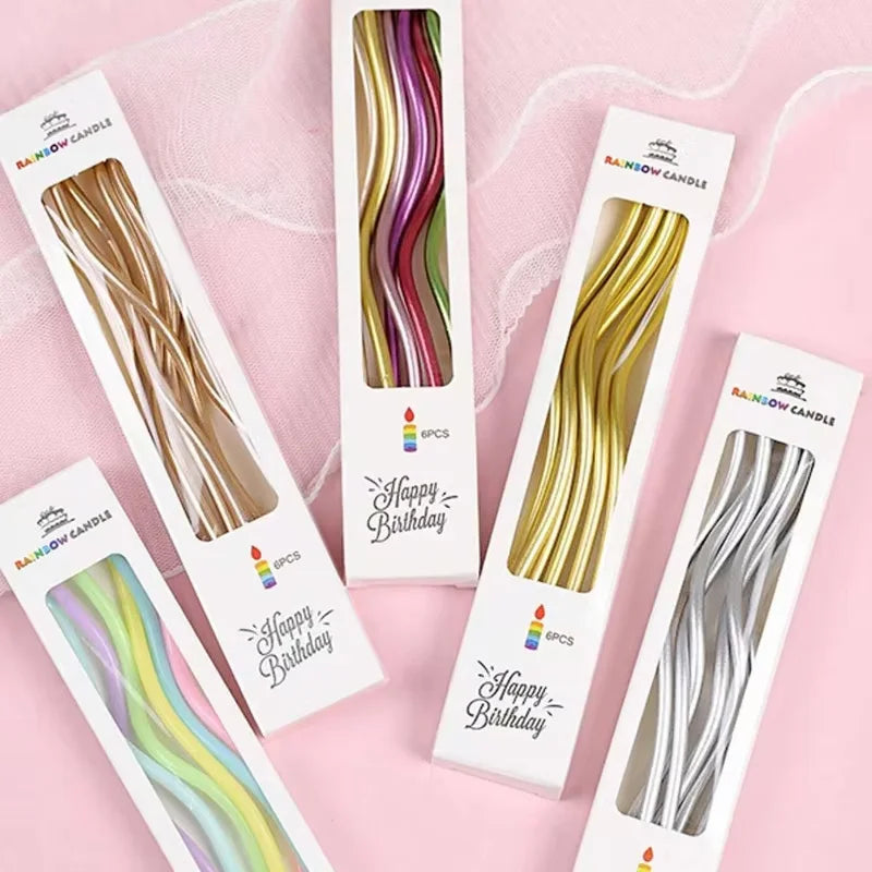 A set of six curved decorative birthday candles in various colors and metallic shades displayed on white packaging.