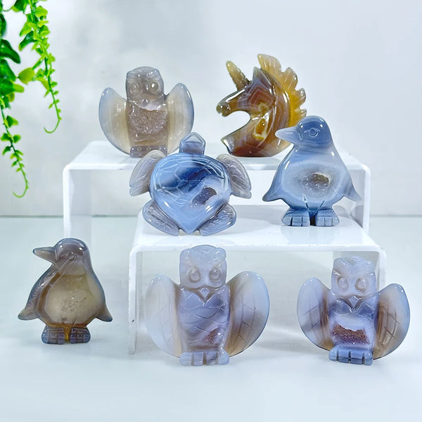 A set of natural agate crystal figurines depicting various birds and animals like an owl, penguin, and lion.