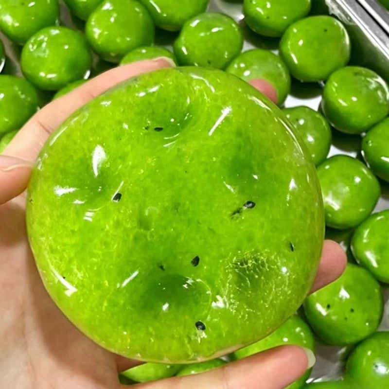 A bright green vaseline-filled cheese squishy stress relief toy is held in a hand, surrounded by similar toys.