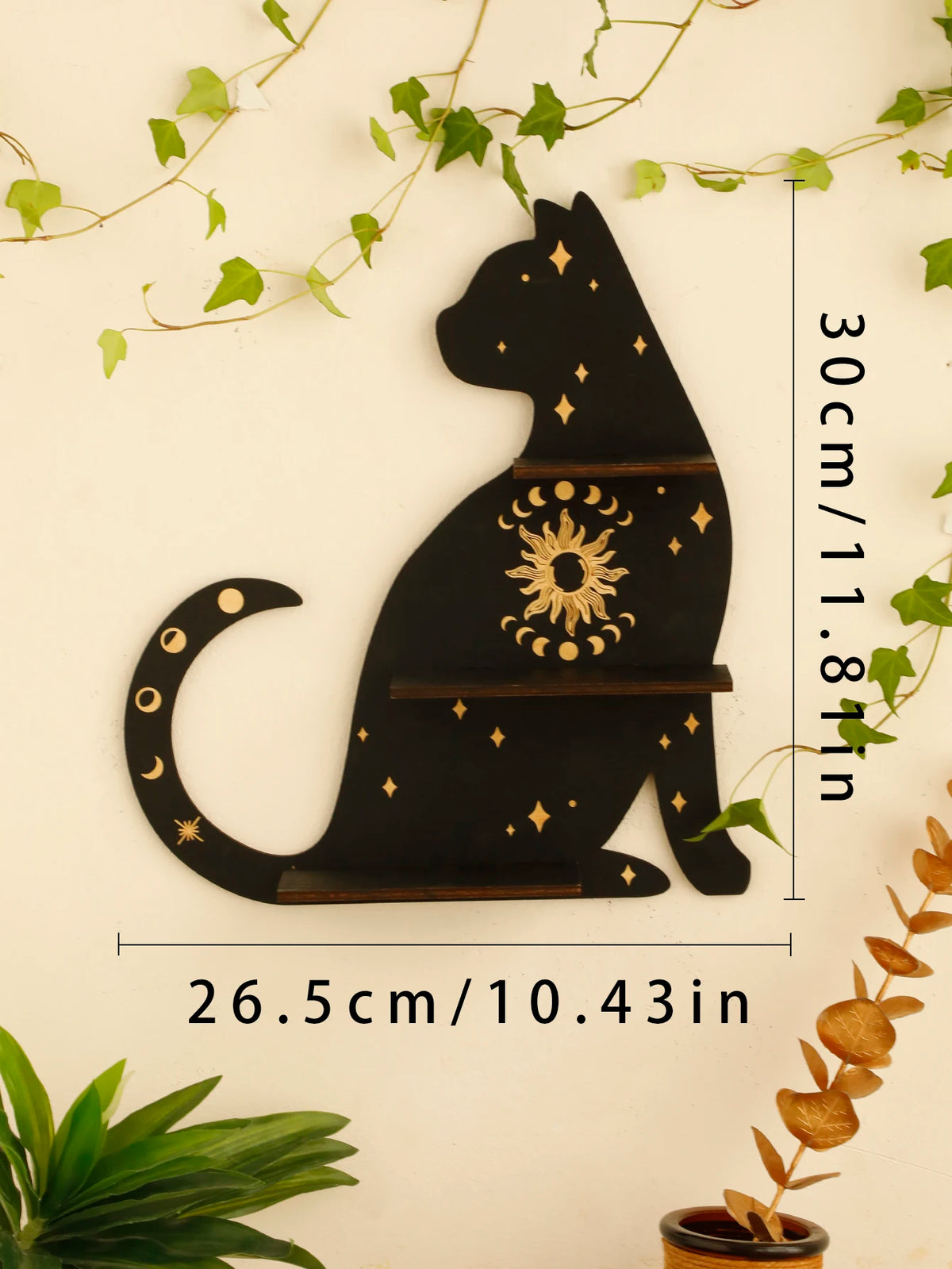 A black silhouette of a cat with gold star accents is displayed on a floating shelf.