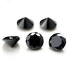 A collection of black, round cut loose stones for jewelry making, including triangular and round shapes.