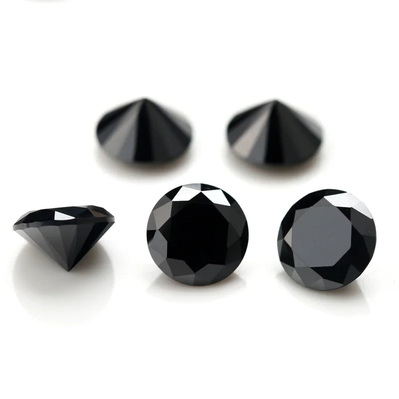 A collection of black, round cut loose stones for jewelry making, including triangular and round shapes.