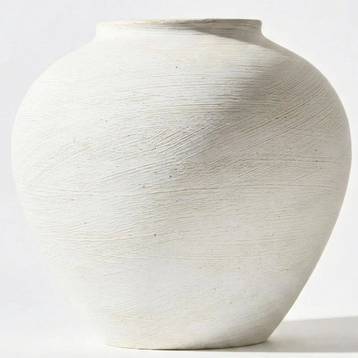 A large, smooth, off-white decorative vase with vertical textured lines.