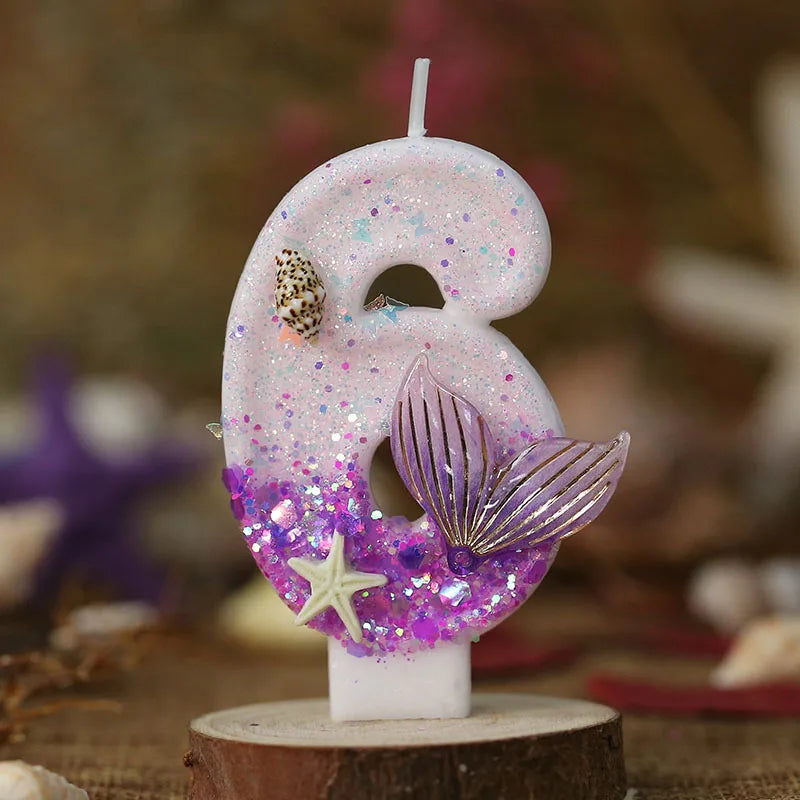 Pink birthday candle shaped like the number 3 with purple glitter and a starfish decoration