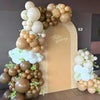A large arrangement of pastel latex balloons in shades of beige and cream decorated for a birthday party.