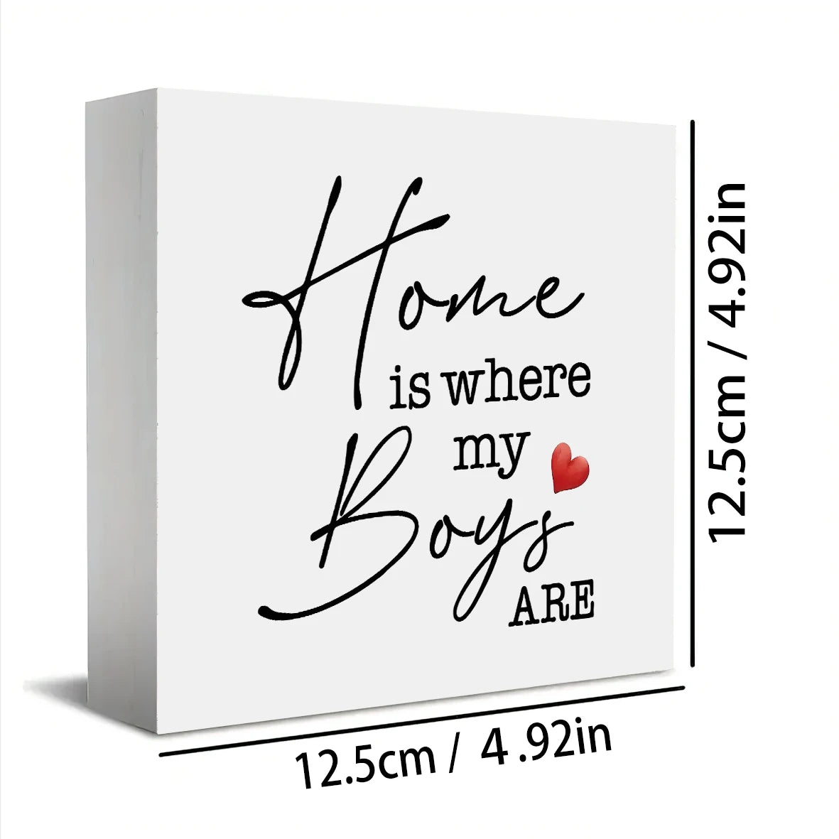 A white rectangular sign with black script text that reads Home is where my Boys are and a small red heart.