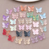 Variedad de cuentas de mariposa de vidrio de colores en tonos rosa, púrpura, azul y verde