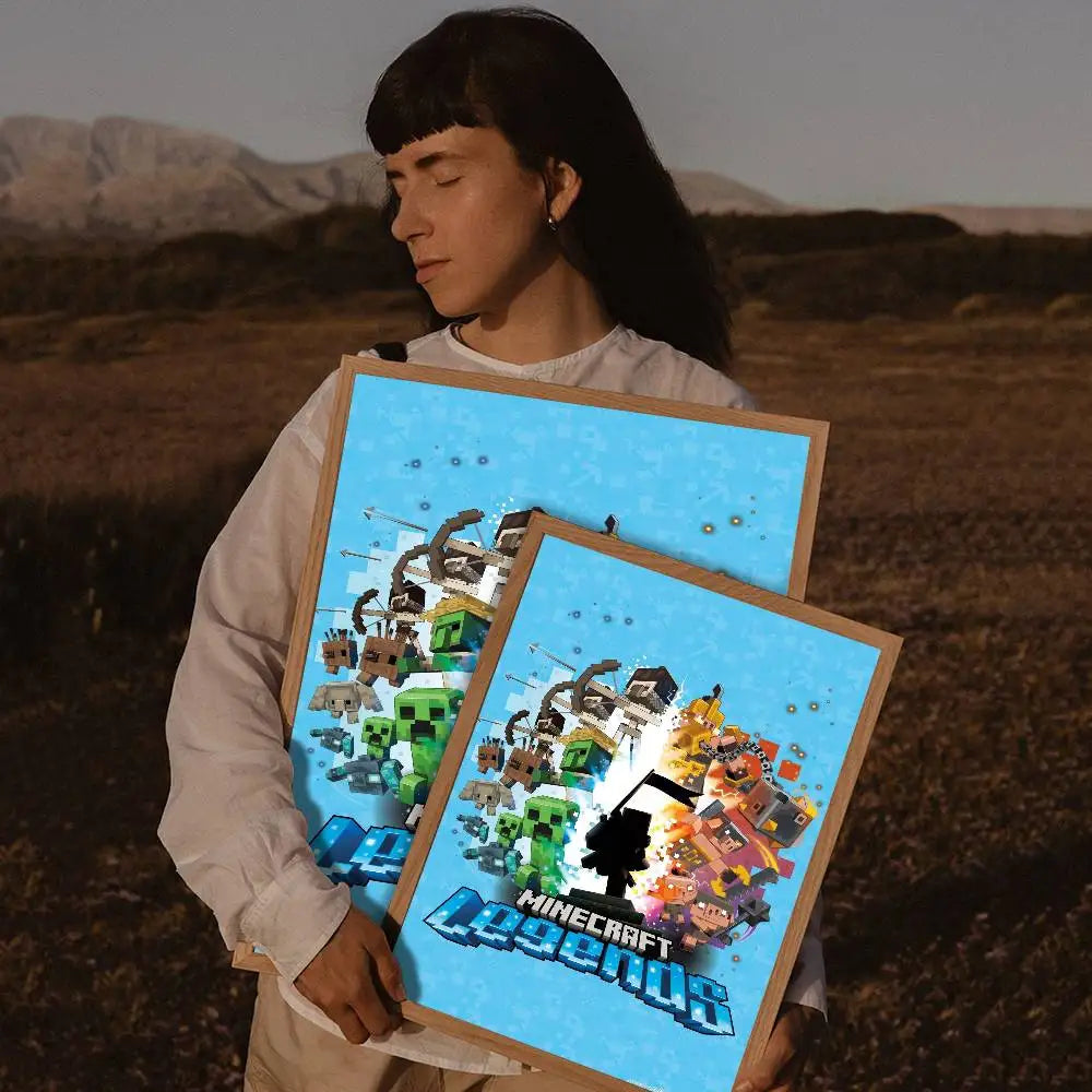 A person holds a framed print featuring Minecraft characters and scenery against a blue background.