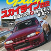 A close-up view of a red sports car, likely a GR Supra, parked on a road with Japanese text promoting a new model.