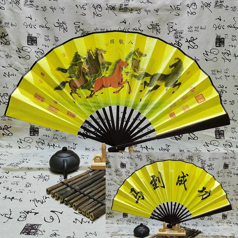 A yellow and black retro folding silk and bamboo decorative fan displayed against a patterned background.